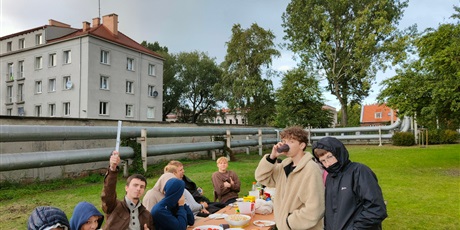 Powiększ grafikę: Na zdjęciu widać wychowanków siedzących przy długim stole, którzy jedzą i rozmawiają