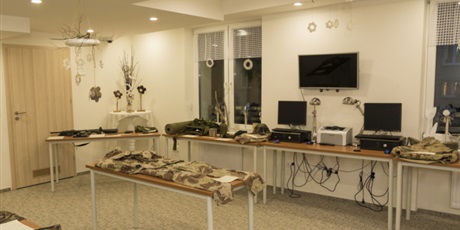 Powiększ grafikę: Na zdjęciu stoliki, na których leży ekwipunek żołnierza armii amerykańskiej z Operacji „Pustynna burza” m.in. mundury, repliki broni, hełm i kamizelka przeciwodłamkowa