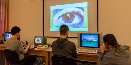 Powiększ grafikę: Troje wychowanków , dwóch z nich gra w gry na starych komputerach, jeden obserwuje zmagania kolegi.