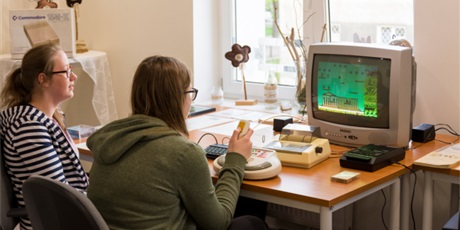 Powiększ grafikę: Na zdjęciu dwie wychowanki siedzące przed telewizorem i grające na retrokomputerze Zx Spectrum w grę Bomb Jack 