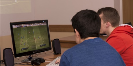 Powiększ grafikę: Dwoje wychowanków podczas rozgrywania na komputerze meczu w Fifę