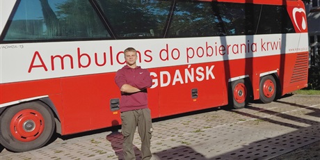 Powiększ grafikę: Na zdjęciu wychowanek stojący przy krwiobusie w RCKiK w Gdańsku