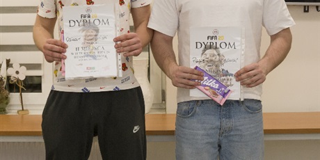 Powiększ grafikę: Dwóch wychowanków stojących i trzymających dyplomy za zajęcie pierwszego i drugiego miejsca w Turnieju Fifa