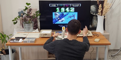 Powiększ grafikę: Na zdjęciu wychowanek grający na komputerze Commodore C64 w grę 1942.