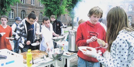 Powiększ grafikę: Wychowankowie na tyłach Bursy Gdańskiej przy ul. Podwale Staromiejskie urządzają grilla. Młodzież nakłada sobie jedzenie ze stołów