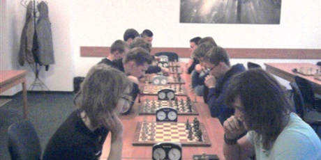 Powiększ grafikę: Siedem szachownic przy których równolegle rozgrywają się pojedynki. Obok szacxhownic ustawione zegary.