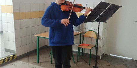 Powiększ grafikę: wychowanek grający kolędy na skrzypcach