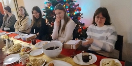 Powiększ grafikę: Na zdjęciu wychowanki siedzące przy stole wigilijnym