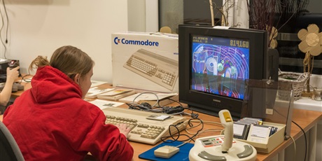 Powiększ grafikę: Na zdjęciu wychowanka siedząca przed telewizorem i grająca na retrokomputerze Amiga 500 w grę Pnball Fantasies