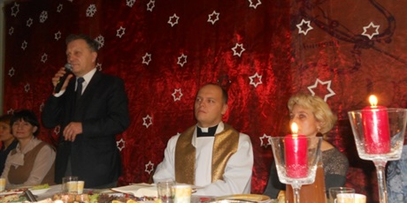 Powiększ grafikę: Dyrektor Bursy Jerzy Serkowski przemawia do mikrofonu. Obok Niego za stołem siedzą zebrani goście, w tle czerwony materiał do którego przyczepiono białe gwiazdki.