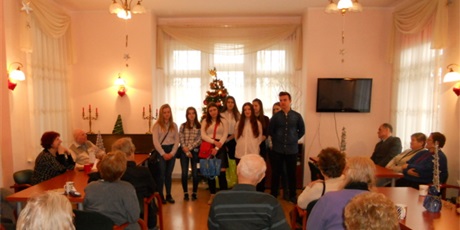 Powiększ grafikę: Na zdjęciu wychowankowie stojący w świetlicy i opowiadający pensjonariuszom Domu Opieki „Pod Cisem” o Bursie Gdańskiej