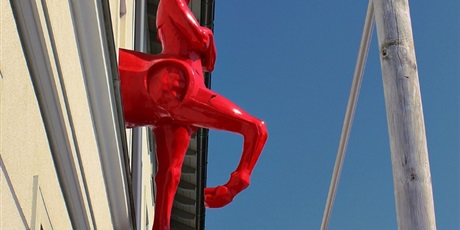 Powiększ grafikę: Czerwony centaur wystający z budynku oliwskiego ratusza kultury.