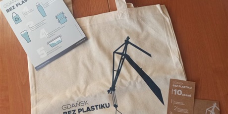 Powiększ grafikę: Na zdjęciu widoczne materiały informacyjne dotyczące akcji „ Gdańsk bez plastiku”/ zakładki do książek, ulotka oraz torba ekologiczna  