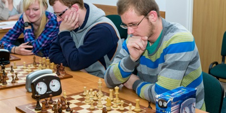 Powiększ grafikę: Troje zawodników w trakcie rozgrywania pojedynku w szachy zastanawia się nad kolejnym ruchem.
